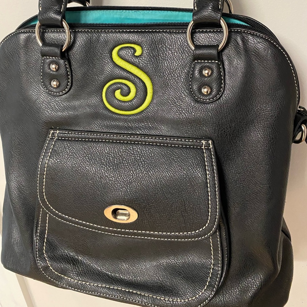 Initials Inc black back with monogram S on front. Multiple pockets